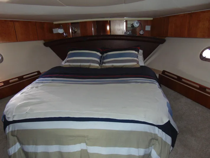 Dividend Yacht Photos Pics Luxurious bedroom interior of 2000 Tiara Yachts 5000 Express with striped bedding.