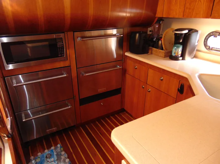 Dividend Yacht Photos Pics Luxurious kitchen in 2000 Tiara Yachts 5000 Express with modern appliances and wood cabinetry.