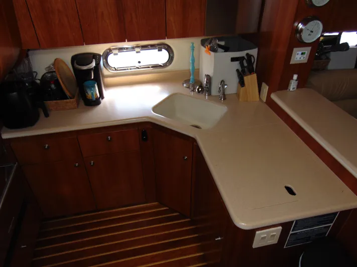 Dividend Yacht Photos Pics 2000 Tiara Yachts 5000 Express kitchen with wooden cabinets and modern appliances.