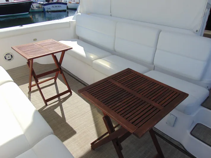Dividend Yacht Photos Pics Spacious seating area on 2000 Tiara Yachts 5000 Express with wooden tables.