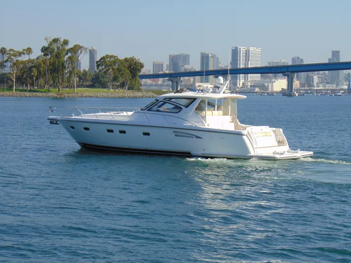 Dividend Yacht Photos Pics 2000 Tiara Yachts 5000 Express cruising near city skyline and bridge.