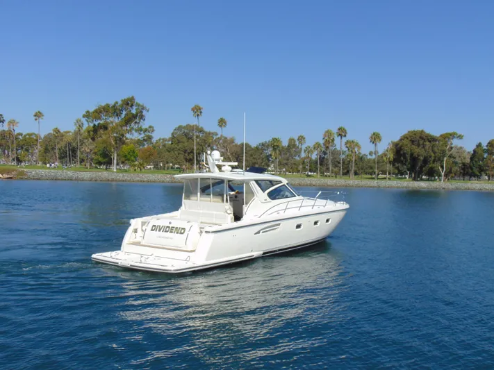 Dividend Yacht Photos Pics 2000 Tiara Yachts 5000 Express cruising on a serene lake with palm trees.