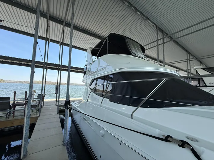 Stress Relief Yacht Photos Pics 2007 Silverton 36 Convertible yacht docked under a covered marina with scenic water view.