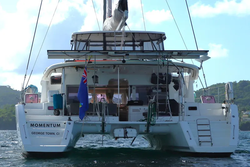 Momentum Yacht Photos Pics 2012 Lagoon 450 F catamaran "Momentum" on water, rear view with flag.