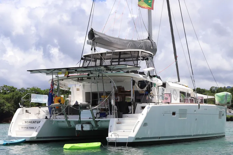 Momentum Yacht Photos Pics 2012 Lagoon 450 F catamaran anchored in calm waters with kayaks nearby.
