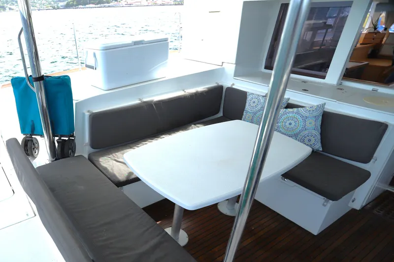 Momentum Yacht Photos Pics Outdoor seating area on a 2012 Lagoon 450 F catamaran with cushions and table.