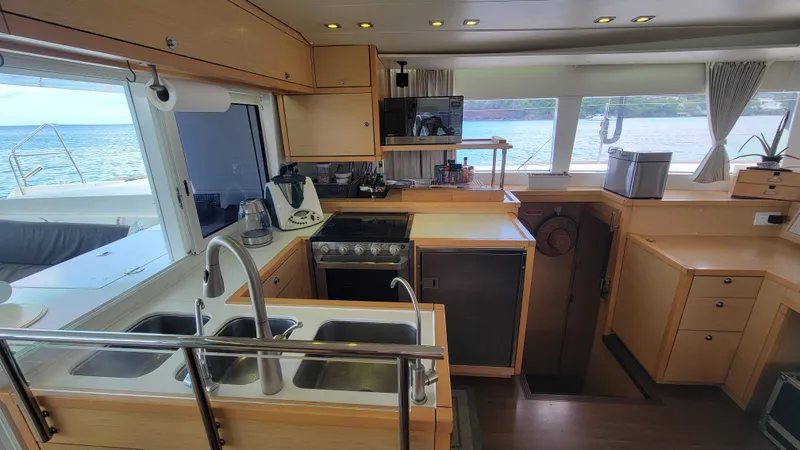 Momentum Yacht Photos Pics Interior of 2012 Lagoon 450 F catamaran kitchen with ocean view through windows.
