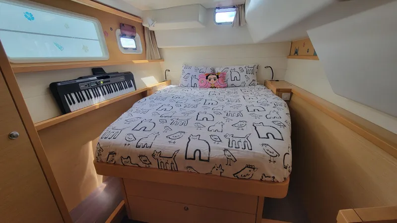 Momentum Yacht Photos Pics Cozy bedroom in 2012 Lagoon 450 F yacht with animal-themed bedding and keyboard.
