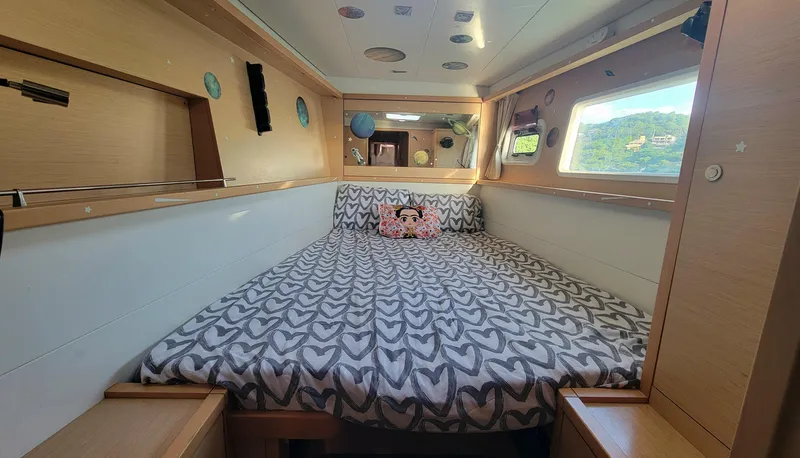 Momentum Yacht Photos Pics Cozy cabin interior of 2012 Lagoon 450 F catamaran with patterned bedding and scenic window view.