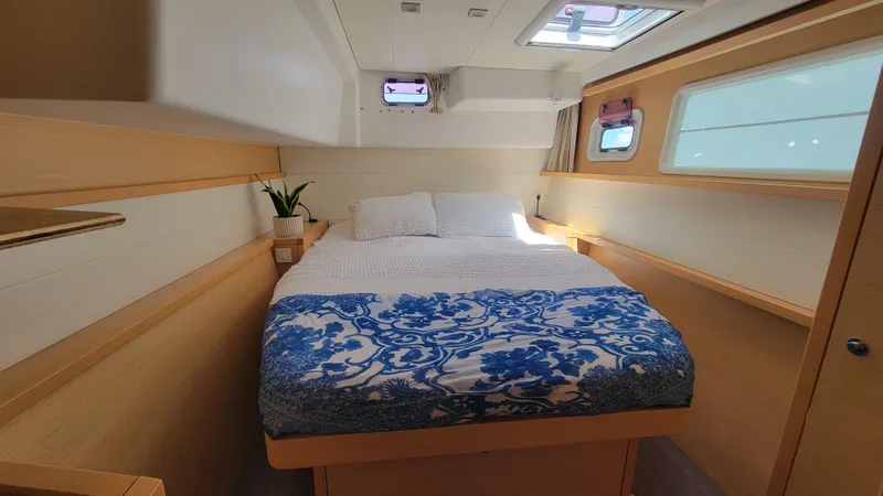 Momentum Yacht Photos Pics Interior cabin of 2012 Lagoon 450 F catamaran with bed and portholes.