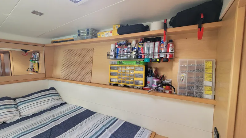 Momentum Yacht Photos Pics Interior of 2012 Lagoon 450 F yacht cabin with bed and organized storage shelves.
