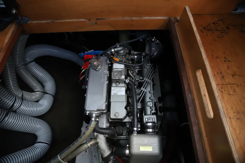 Momentum Yacht Photos Pics Engine compartment of a 2012 Lagoon 450 F catamaran, showcasing mechanical components and hoses.