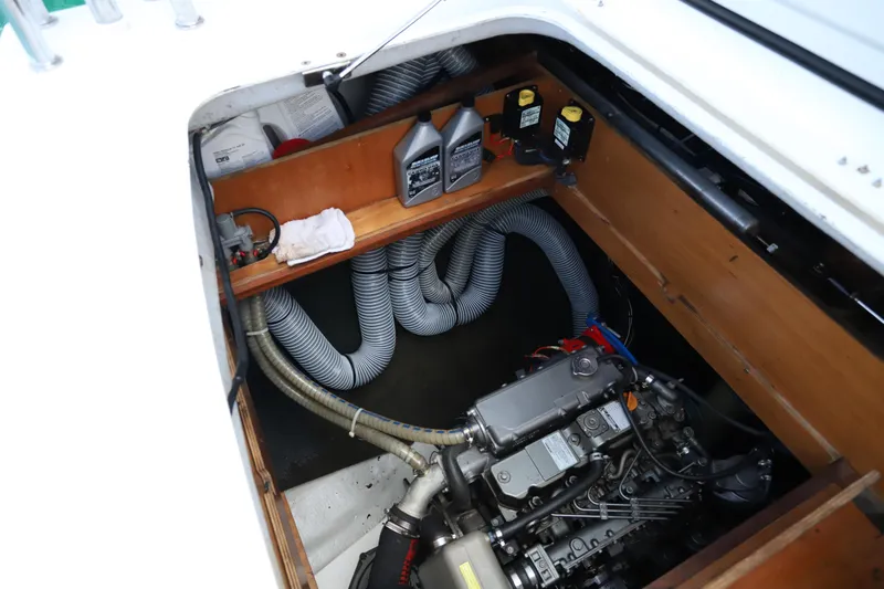 Momentum Yacht Photos Pics Engine compartment of a 2012 Lagoon 450 F catamaran with visible hoses and oil containers.