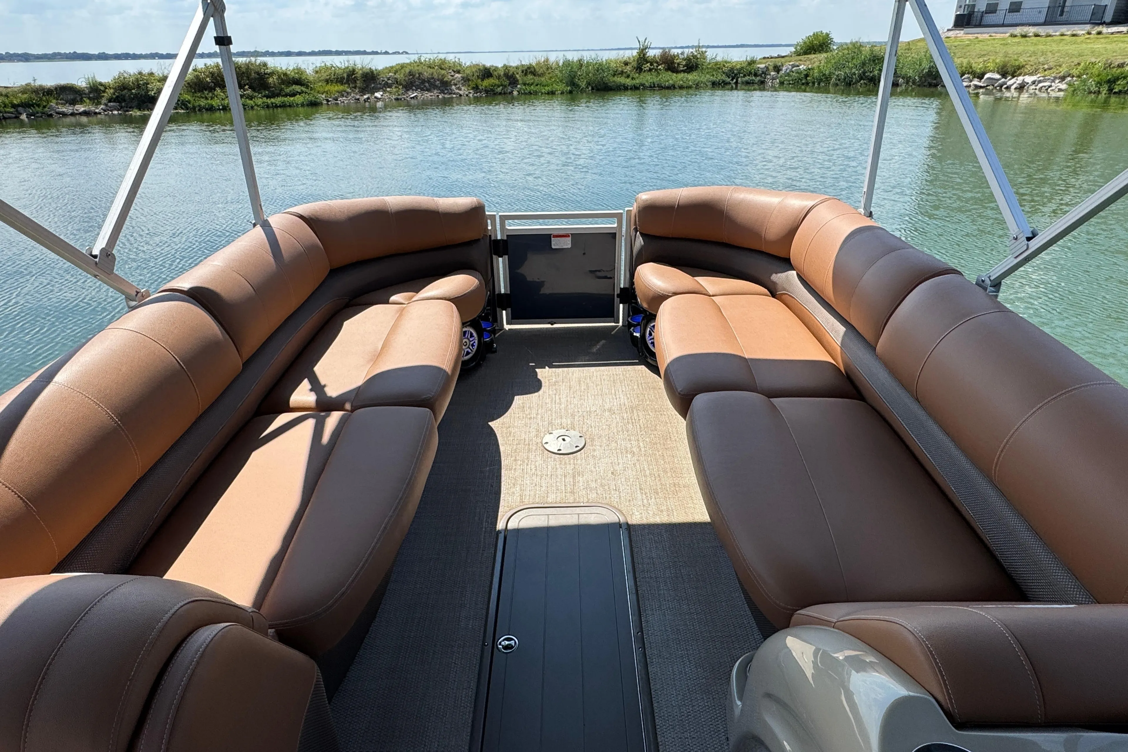 Luxurious seating on 2017 Regency 254 LE3 pontoon boat, docked by serene water.