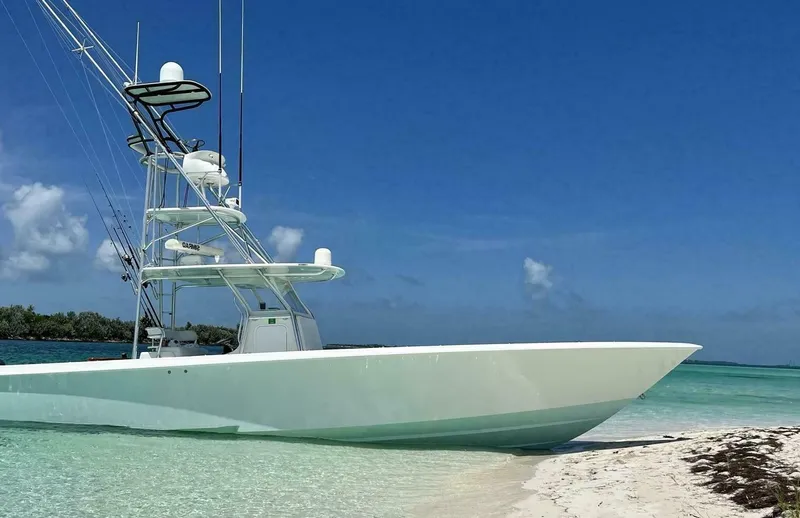 Nauty C Bouys Yacht Photos Pics 2012 Contender 39ST boat anchored on a sandy beach with clear blue skies.