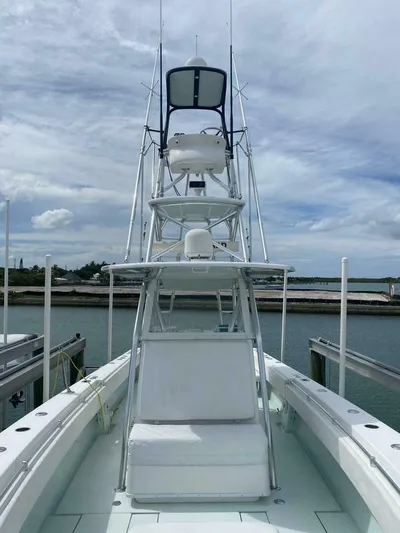 Nauty C Bouys Yacht Photos Pics 2012 Contender 39ST boat with tower, docked under a cloudy sky.