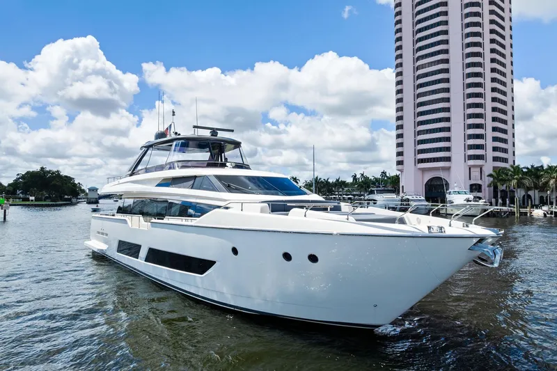 Alter Ego Yacht Photos Pics 2018 Ferretti Yachts 850 Motoryacht docked near a tall building, under a blue sky.