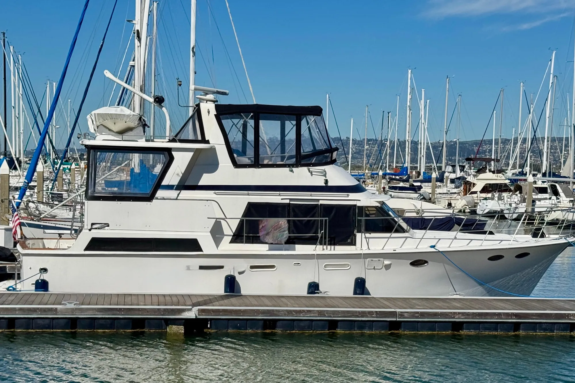 1987 Lien Hwa 47 Cockpit Motor Yacht docked in marina, clear sky background.