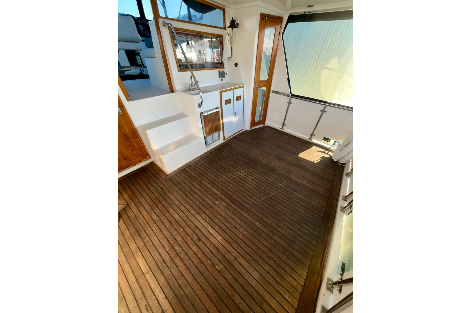 1987 Lien Hwa 47 Cockpit Motor Yacht interior with wooden flooring and seating area.