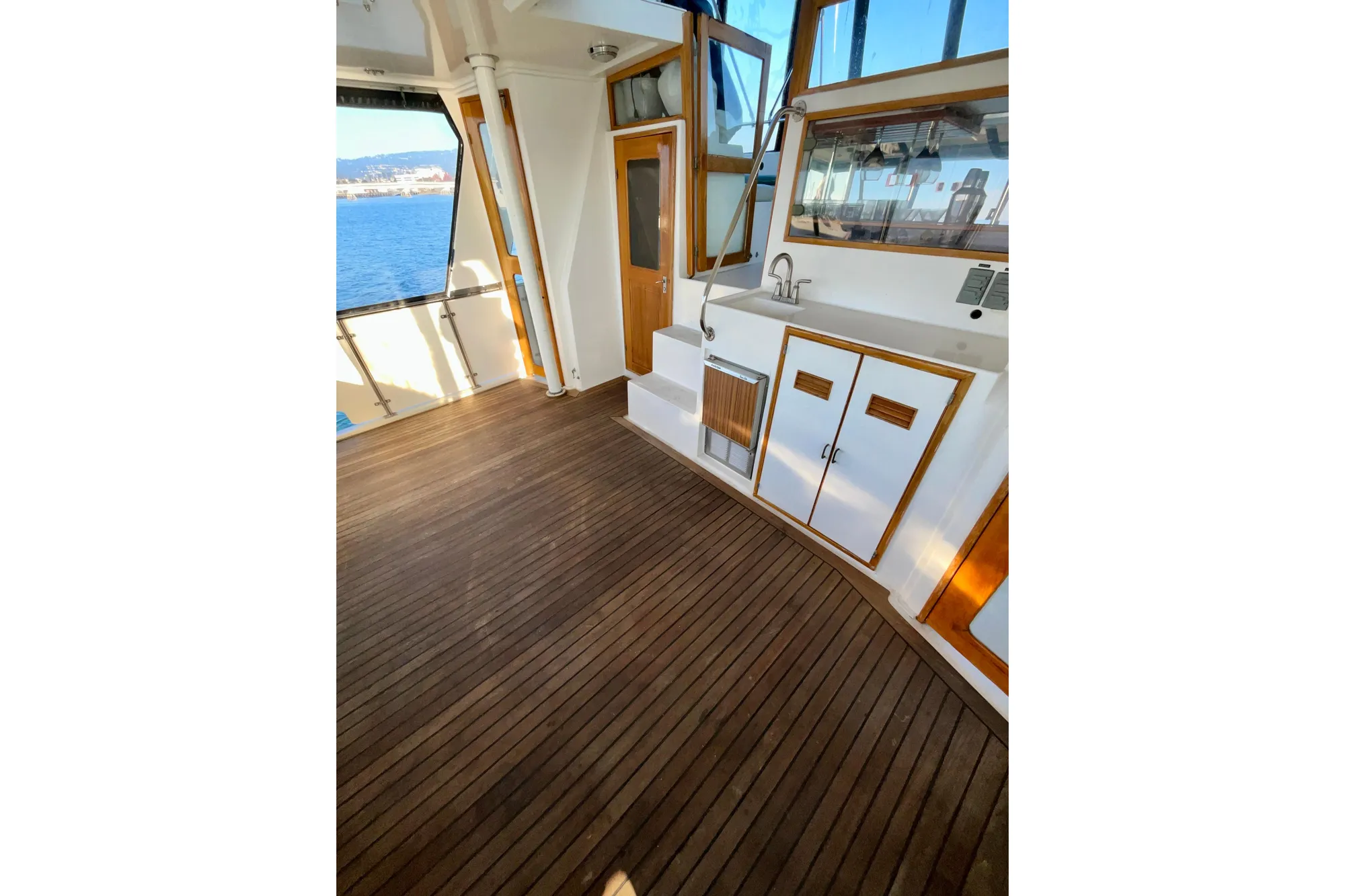 1987 Lien Hwa 47 Cockpit Motor Yacht interior with wooden flooring and kitchenette.