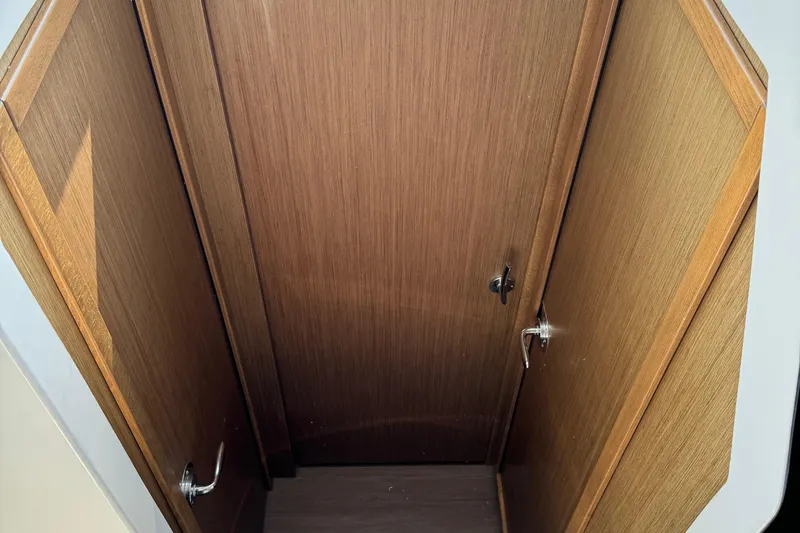 Plumper Yacht Photos Pics Wooden interior of 2019 Jeanneau NC 895 boat cabin with door handles.
