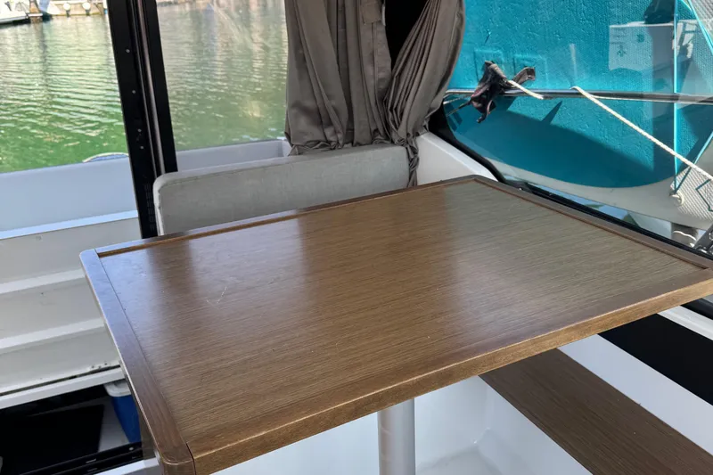 Plumper Yacht Photos Pics Interior of 2019 Jeanneau NC 895 boat with wooden table and window view.