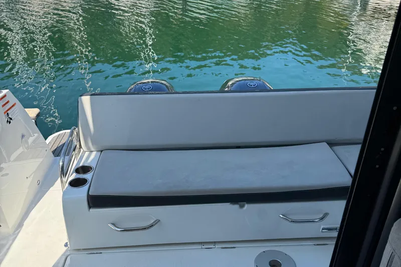 Plumper Yacht Photos Pics 2019 Jeanneau NC 895 boat with cushioned seating and cup holders by the water.