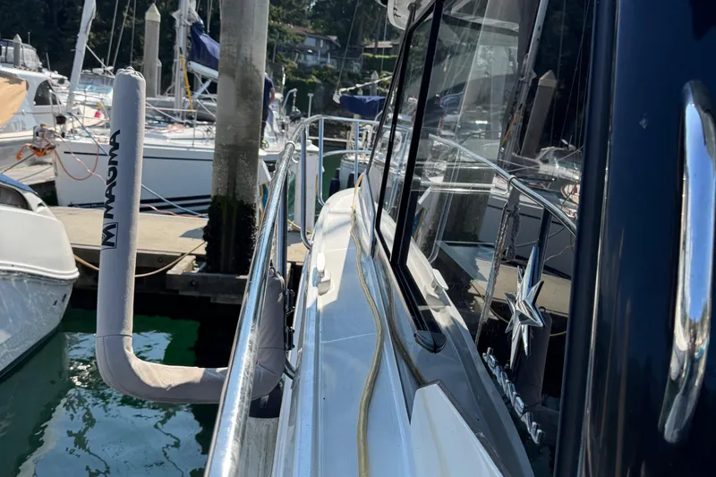 Plumper Yacht Photos Pics 2019 Jeanneau NC 895 docked at marina, side view with reflections.