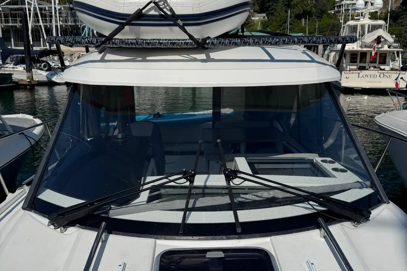 Plumper Yacht Photos Pics 2019 Jeanneau NC 895 boat docked, featuring windshield and roof-mounted equipment.