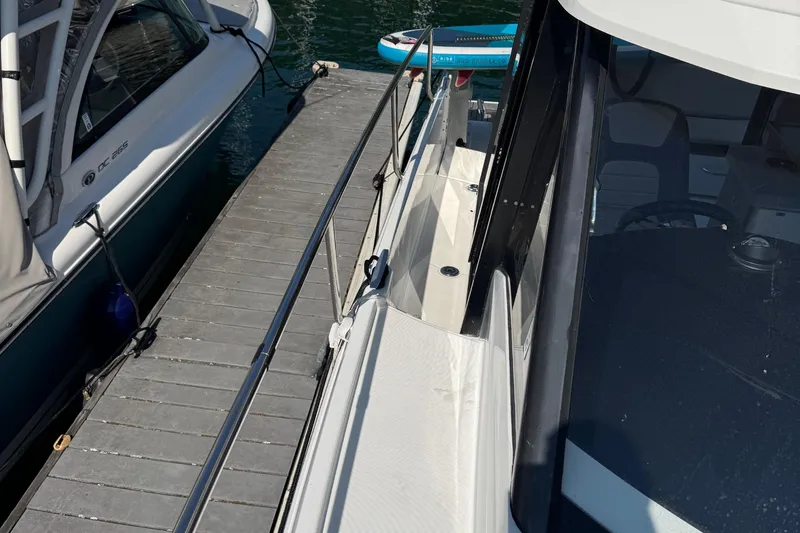 Plumper Yacht Photos Pics 2019 Jeanneau NC 895 docked beside another boat, with visible walkway and railing.