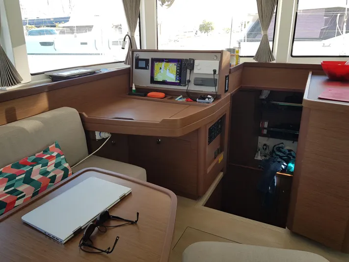 Kaya Yacht Photos Pics Interior of 2021 Lagoon 42 catamaran with navigation station and cozy seating area.