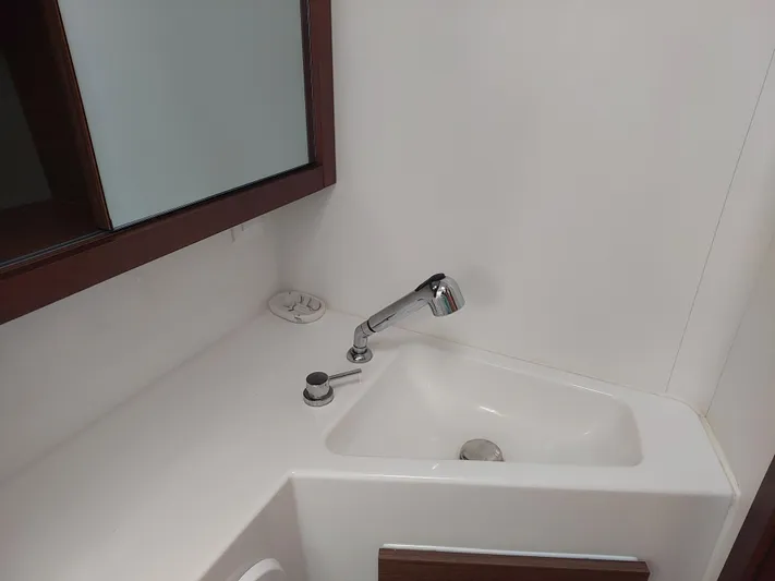 Kaya Yacht Photos Pics Compact bathroom sink in a 2021 Lagoon 42 yacht, featuring a modern faucet and mirror.