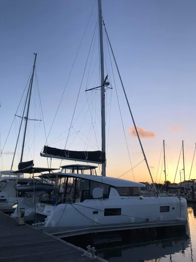 Kaya Yacht Photos Pics 2021 Lagoon 42 catamaran docked at sunset in a marina.