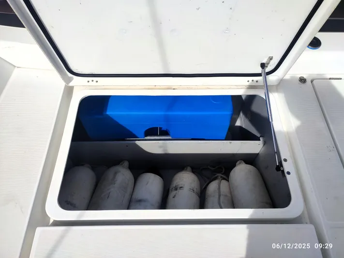 Kaya Yacht Photos Pics Open storage compartment on a 2021 Lagoon 42 boat with fenders and a blue container.