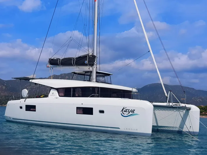 Kaya Yacht Photos Pics 2021 Lagoon 42 catamaran sailing on blue waters under a partly cloudy sky.