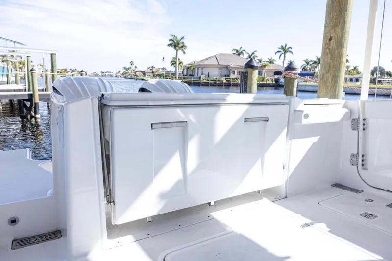  Yacht Photos Pics 2023 Pursuit S 328 Sport boat docked, showcasing sleek design and spacious deck area.