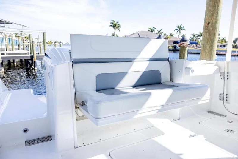  Yacht Photos Pics 2023 Pursuit S 328 Sport boat interior with cushioned seating by the water.