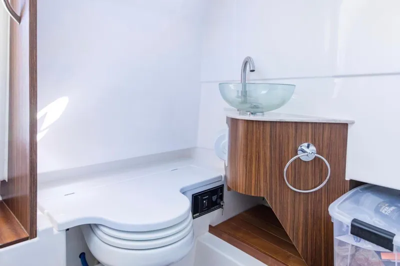  Yacht Photos Pics 2023 Pursuit S 328 Sport boat bathroom with modern sink and wooden accents.