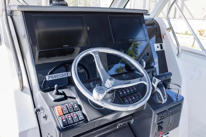  Yacht Photos Pics 2023 Pursuit S 328 Sport boat dashboard with dual screens and steering wheel.