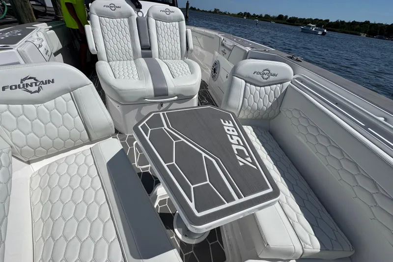  Yacht Photos Pics Luxurious 2025 Fountain 38 SCX boat interior with stylish seating and table on a sunny day.