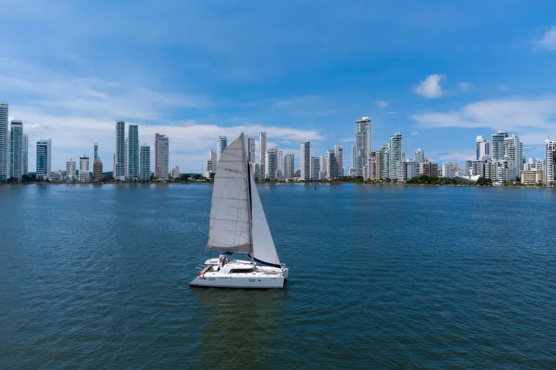 Agm26a09z3354 Yacht Photos Pics Sailboat Lagoon 440, 2010 model, cruising near city skyline on a sunny day.