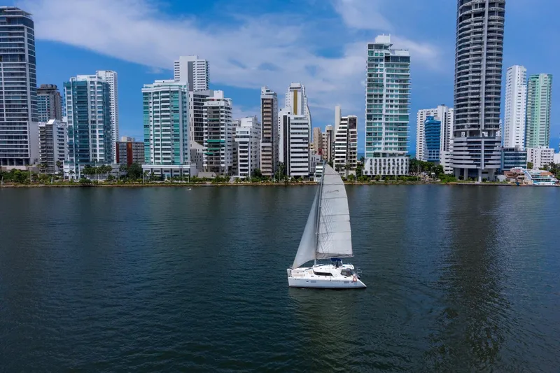 Agm26a09z3354 Yacht Photos Pics Sailboat Lagoon 440 (2010) cruising near modern city skyline on a sunny day.