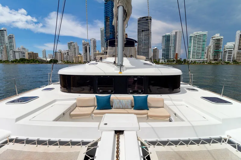 Agm26a09z3354 Yacht Photos Pics 2010 Lagoon 440 catamaran with city skyline backdrop, featuring spacious deck and seating area.