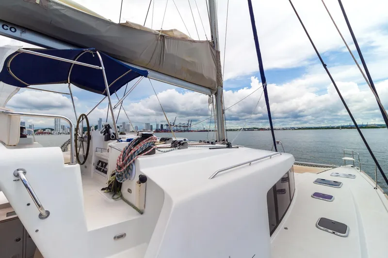 Agm26a09z3354 Yacht Photos Pics 2010 Lagoon 440 catamaran sailing on calm waters with city skyline in background.