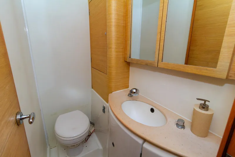 Agm26a09z3354 Yacht Photos Pics Compact bathroom in 2010 Lagoon 440 yacht with toilet, sink, and wooden cabinetry.