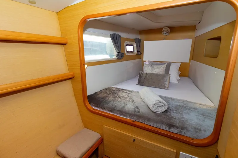 Agm26a09z3354 Yacht Photos Pics Cozy cabin interior of 2010 Lagoon 440 catamaran with bed, pillows, and window view.