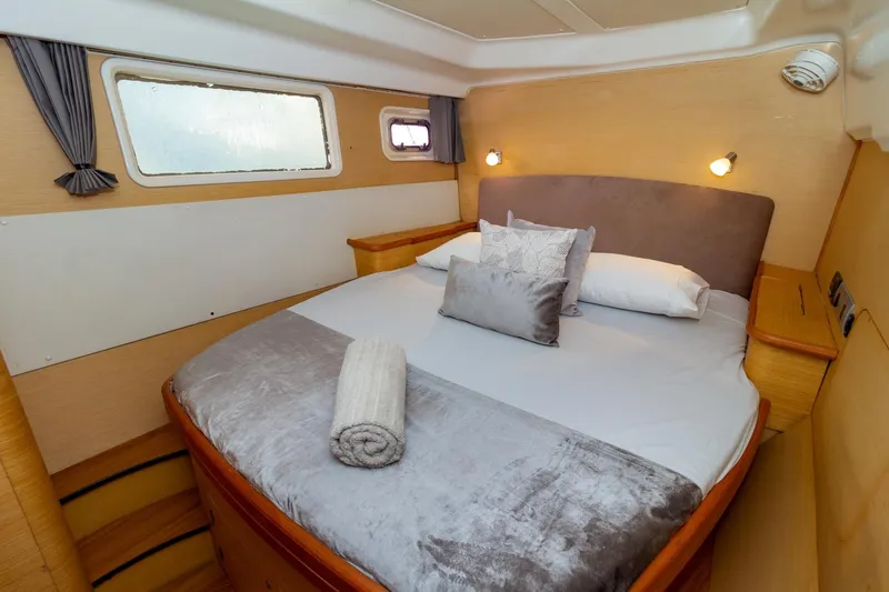 Agm26a09z3354 Yacht Photos Pics Luxurious cabin interior of 2010 Lagoon 440 catamaran with cozy bed and elegant decor.