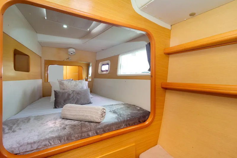 Agm26a09z3354 Yacht Photos Pics Interior cabin of 2010 Lagoon 440 catamaran with cozy bedding and wooden accents.