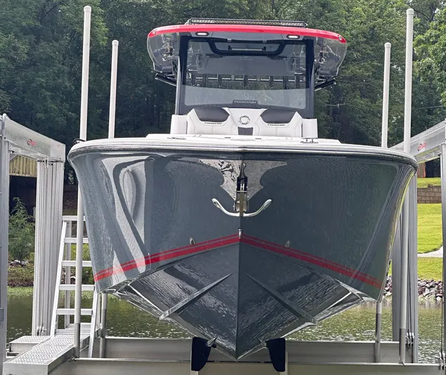  Yacht Photos Pics 2024 Fountain 32 NX boat on lift, sleek design, gray with red accents, forest background.