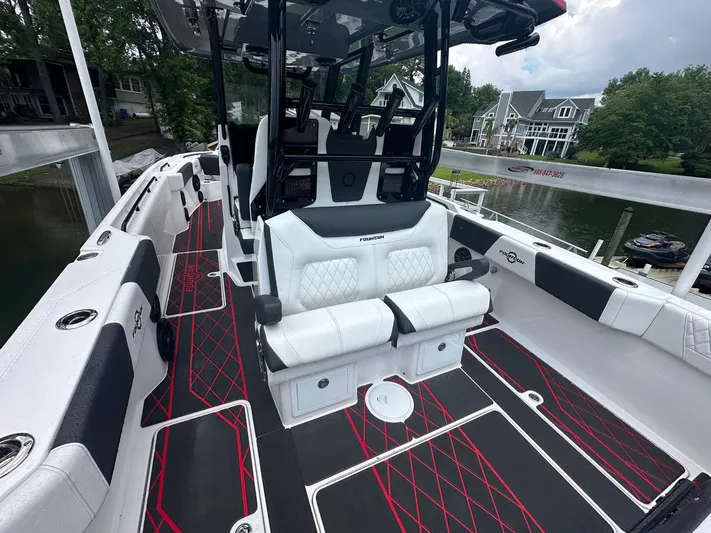  Yacht Photos Pics 2024 Fountain 32 NX boat interior with luxurious seating and modern design by the waterfront.